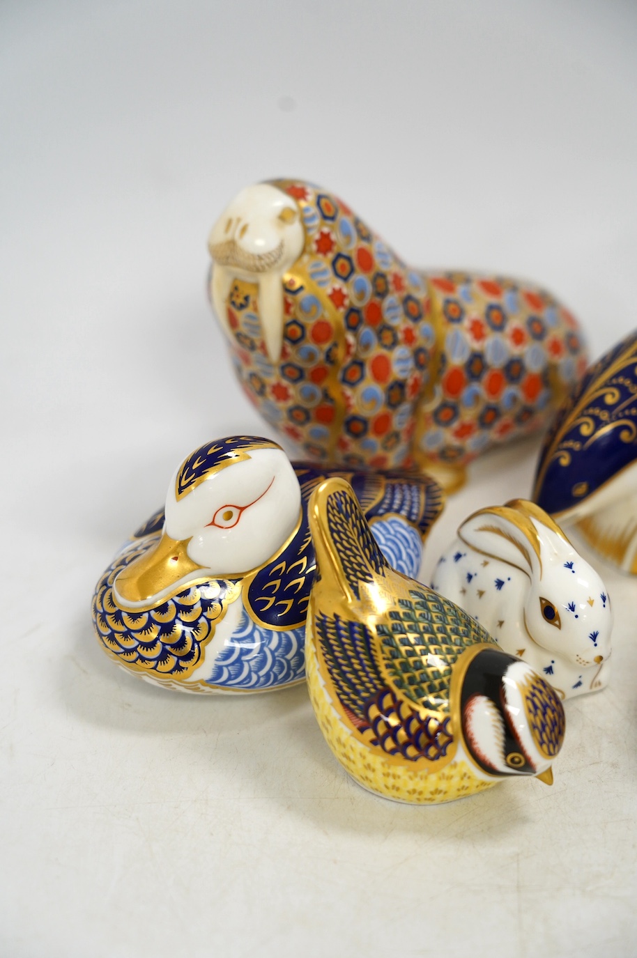 Eight Royal Crown Derby porcelain paperweights in the form of animals including a penguin, rabbit and seal, largest 17cm wide. Condition - seven good, one broken